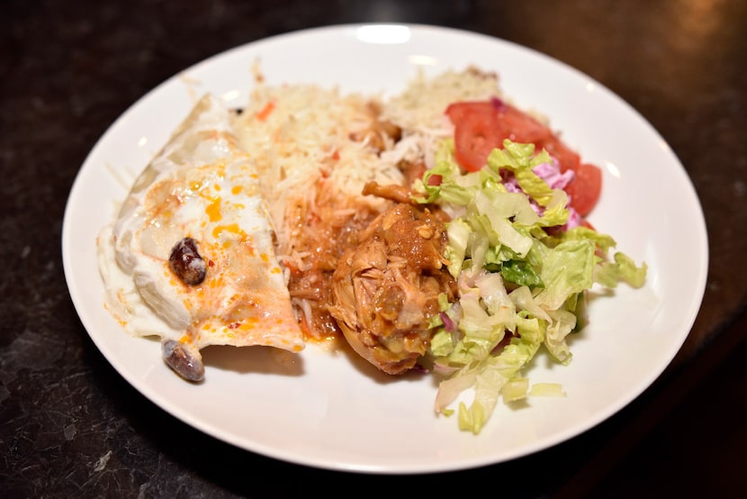 A dish of mantu (beef dumpling), rice, chicken korma and Afghan salad prepared by Jamileh...