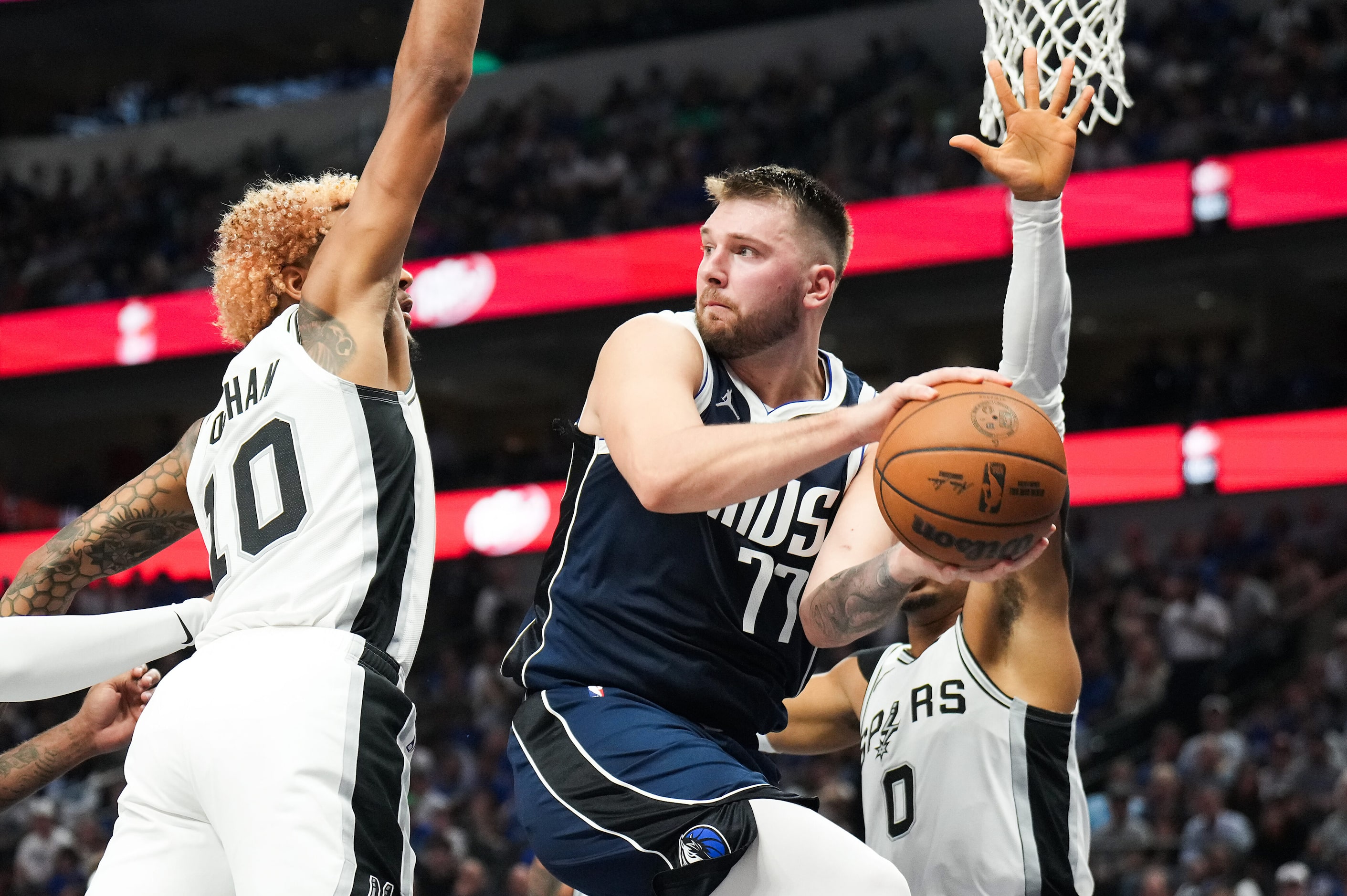 Dallas Mavericks guard Luka Doncic (77) passes the ball around San Antonio Spurs forward...