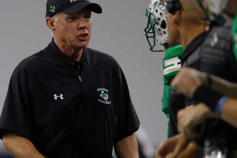 Southlake Carroll head coach Hal Wasson speaks with one of his players on the sideline...