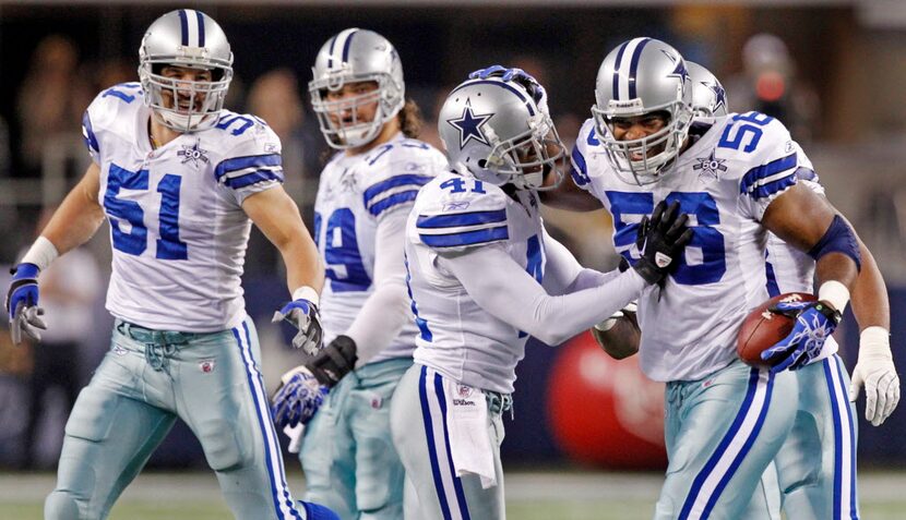 Dallas LB Keith Brooking (51) watches as CB Terence Newman (41) congratulates LB Bradie...