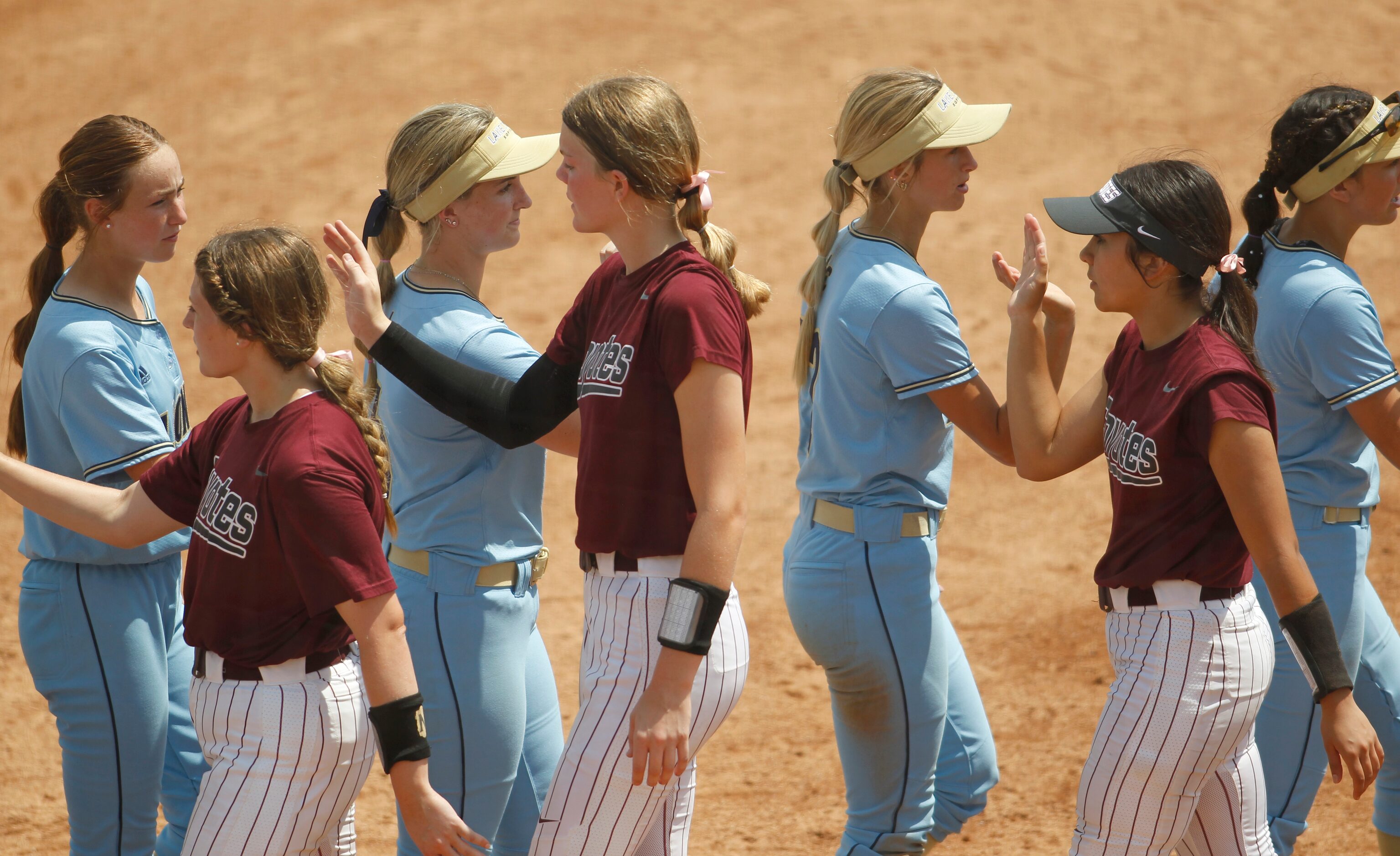 Frisco Heritage players (foreground) shake hands with Montgomery Lake Creek players...