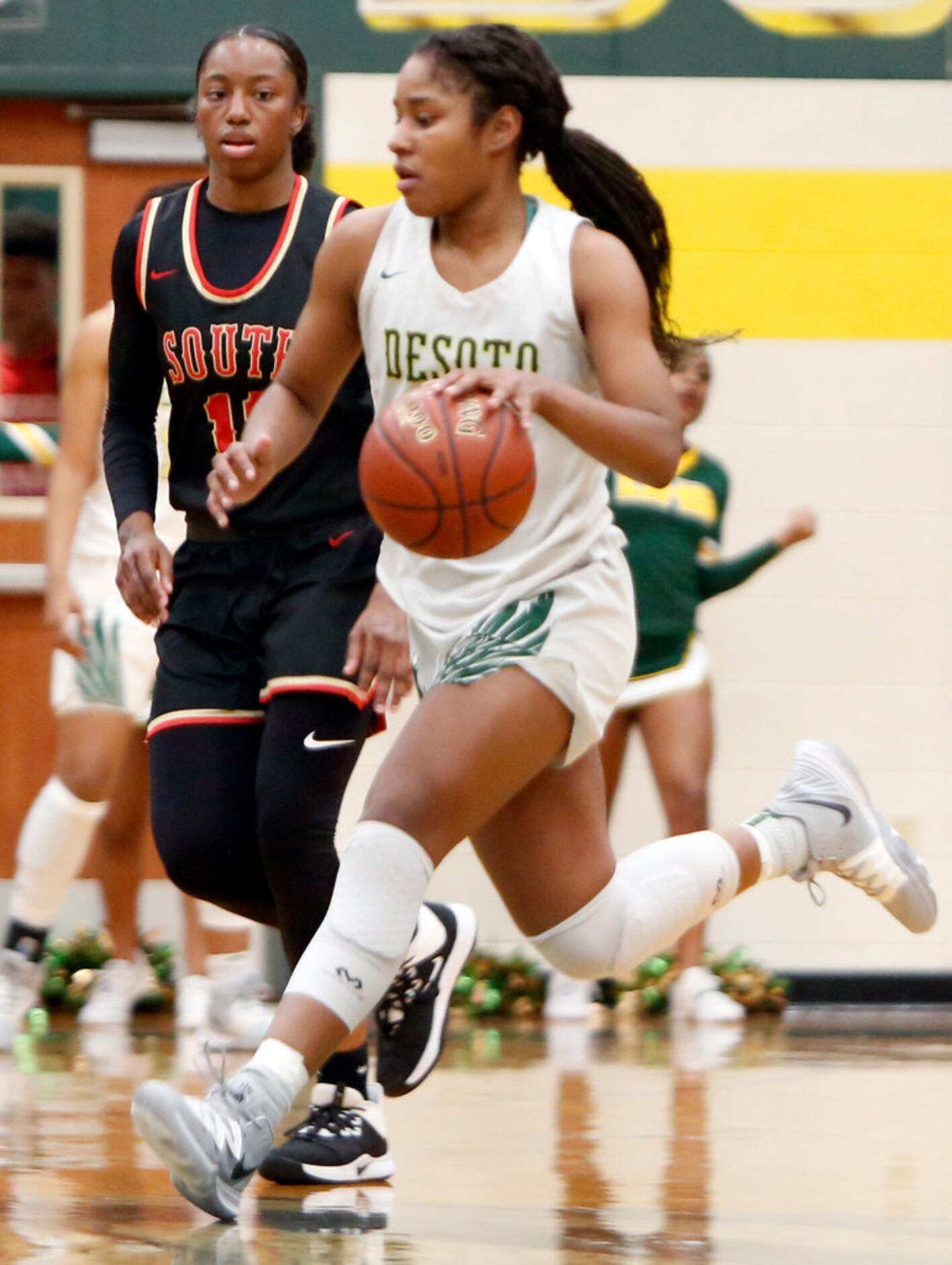 DeSoto's Ash'a Thompson (25) brings the ball down as she is guarded by South Grand Prairie's...