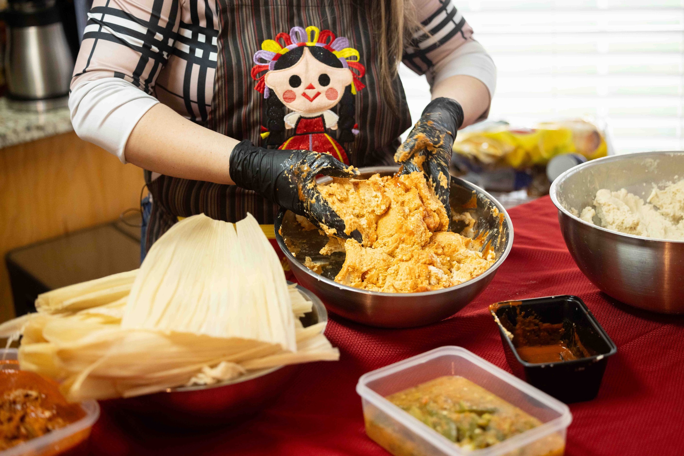 Sara Klein, the hostess behind the evening’s “tamalada,” adds red sauce to the masa at her...