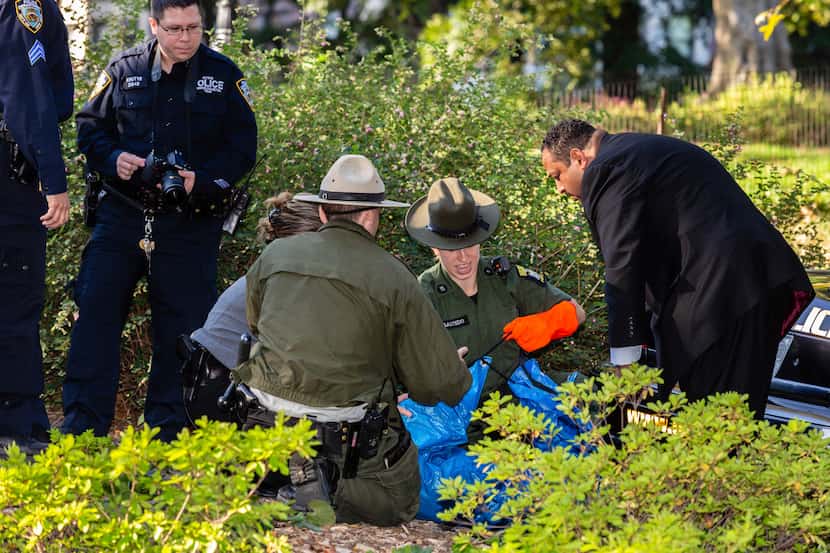 New York Police and New York State Environmental Conservation officers handle the body of...