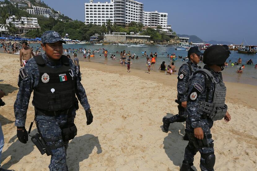 
Mexican police officers patrol Caleta beach in Acapulco amid a wave of violence attributed...
