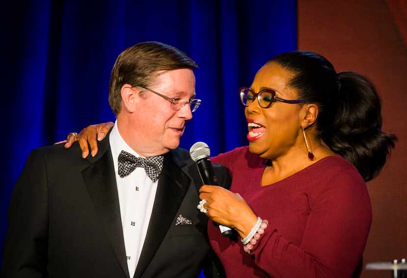 Oprah Winfrey puts her arm around Jim Lentz, chief executive officer of Toyota Motor North...