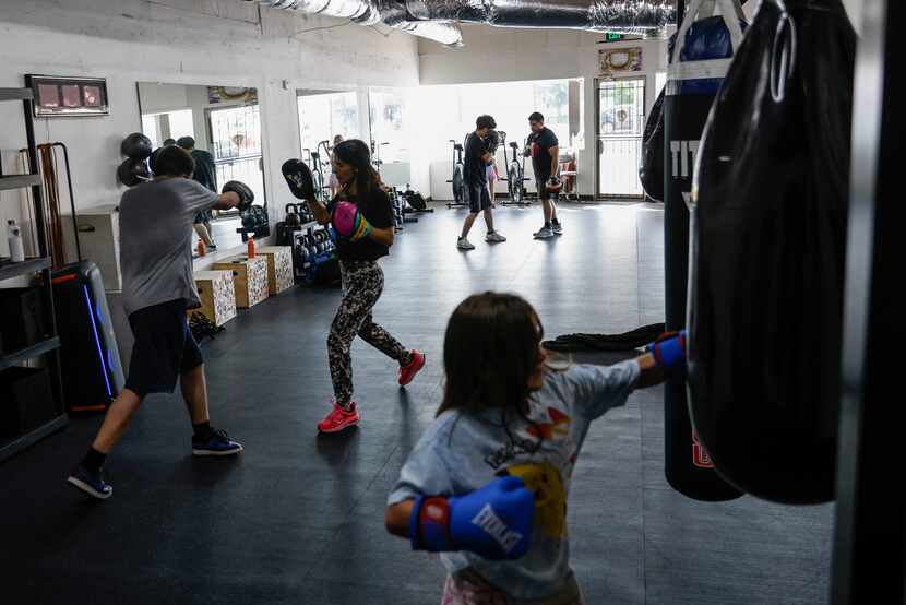 Amanda Alvarez, a salsa teacher and boxing lover, trains Eduardo Soto (left) during a boxing...