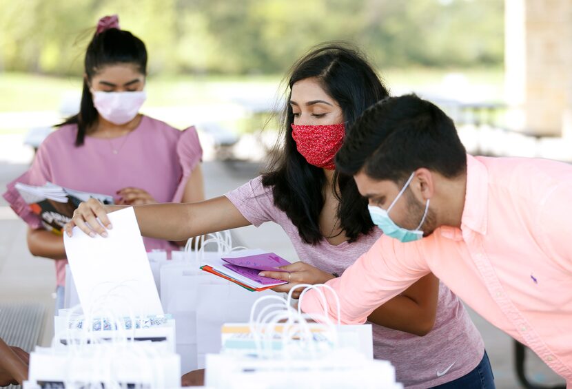 COVID Check-In volunteers assemble care packages for seniors at Windhaven Meadows Park in...