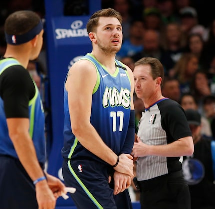 Dallas Mavericks guard Luka Doncic (77) grabs his hand after a play in a game against the...