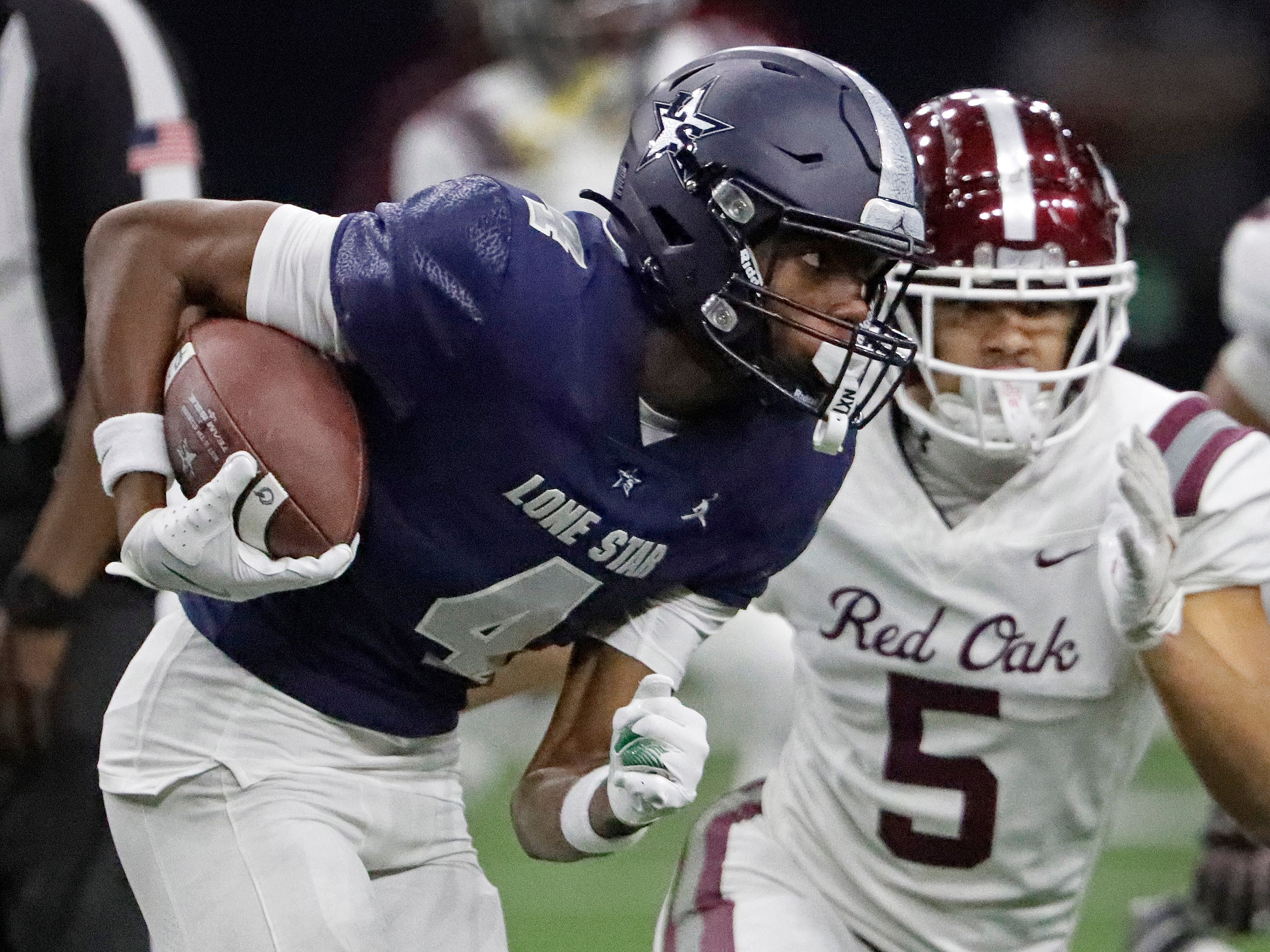 Lone Star High School wide receiver Bryson Jones (4) tries to get past Red Oak High School...