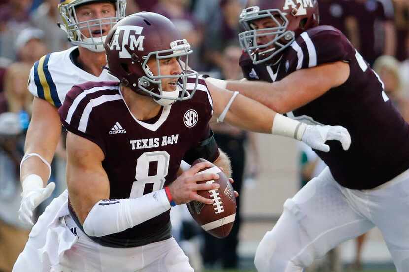 Texas A&M quarterback Trevor Knight (8) scrambles as he looks for an open receiver in the...
