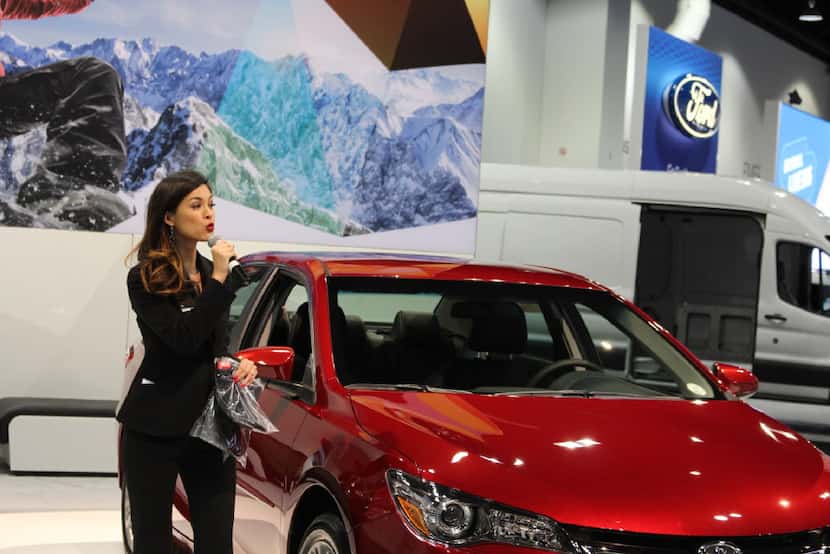 Isabelle Du, a Production Plus employee, talks about a Toyota at the Denver Auto Show in...
