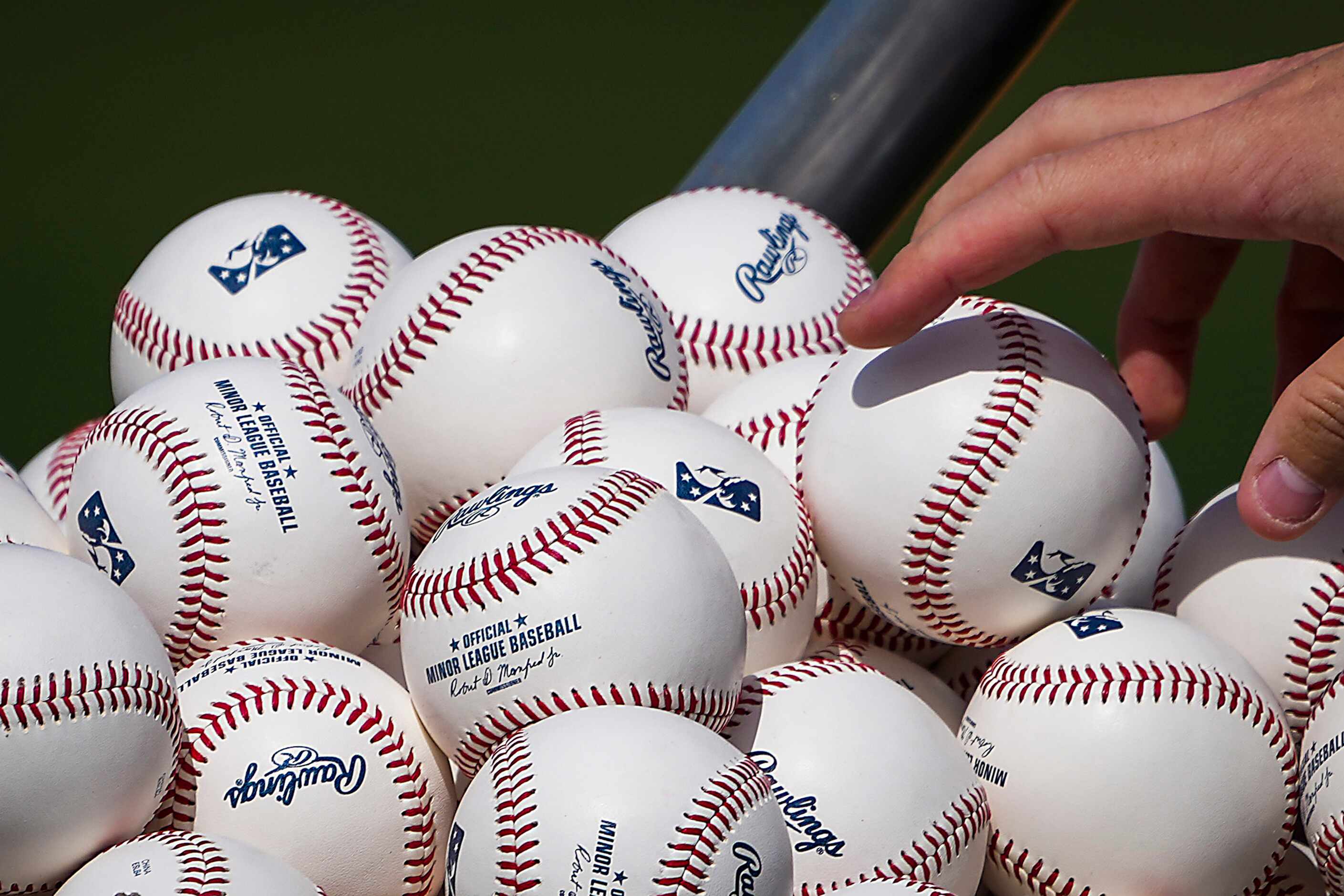 A player reaches into a basked of baseballs  during the Texas Rangers first minor league...