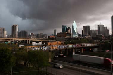 Storm clouds move over downtown Dallas as trains and traffic move along Interstate 35E on...