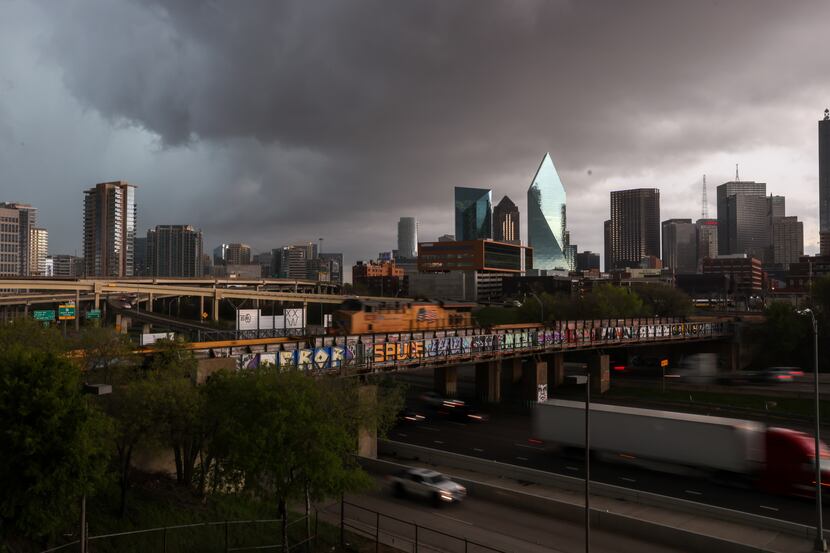 Storm clouds move over downtown Dallas as trains and traffic move along Interstate 35E.