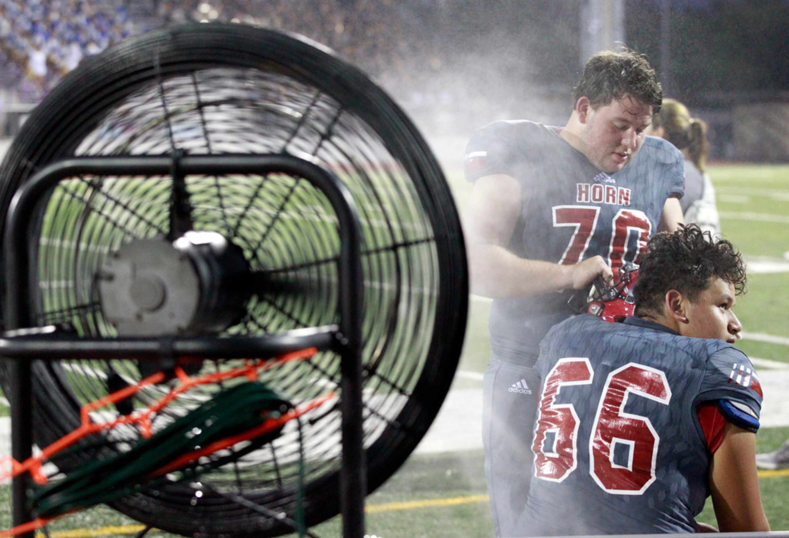 John Horn linemen Rylie James (70) and Moises Castillo (66) chill out under a mister during...