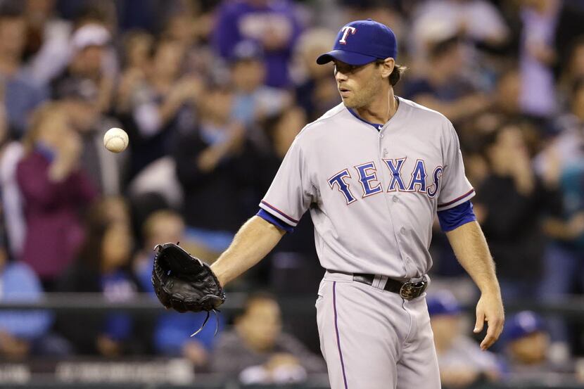 Texas Rangers relief pitcher Neal Cotts gets the ball back against the Seattle Mariners in a...