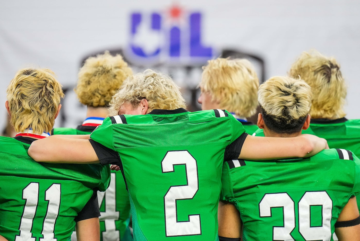 Southlake Carroll quarterback Angelo Renda (2) puts his arms around teammates Brock Boyd...