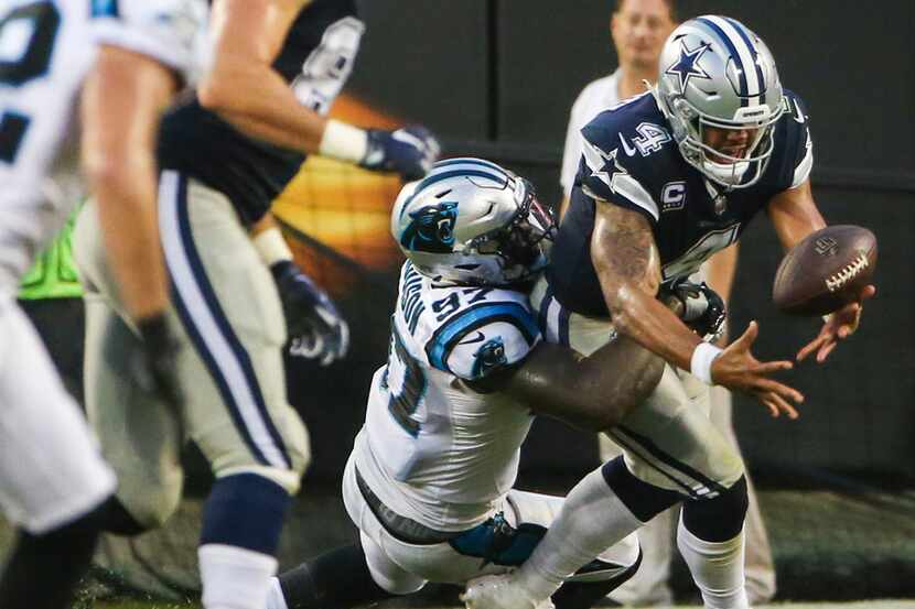 Dallas Cowboys quarterback Dak Prescott (4) fumbles the ball as he is brought down by...