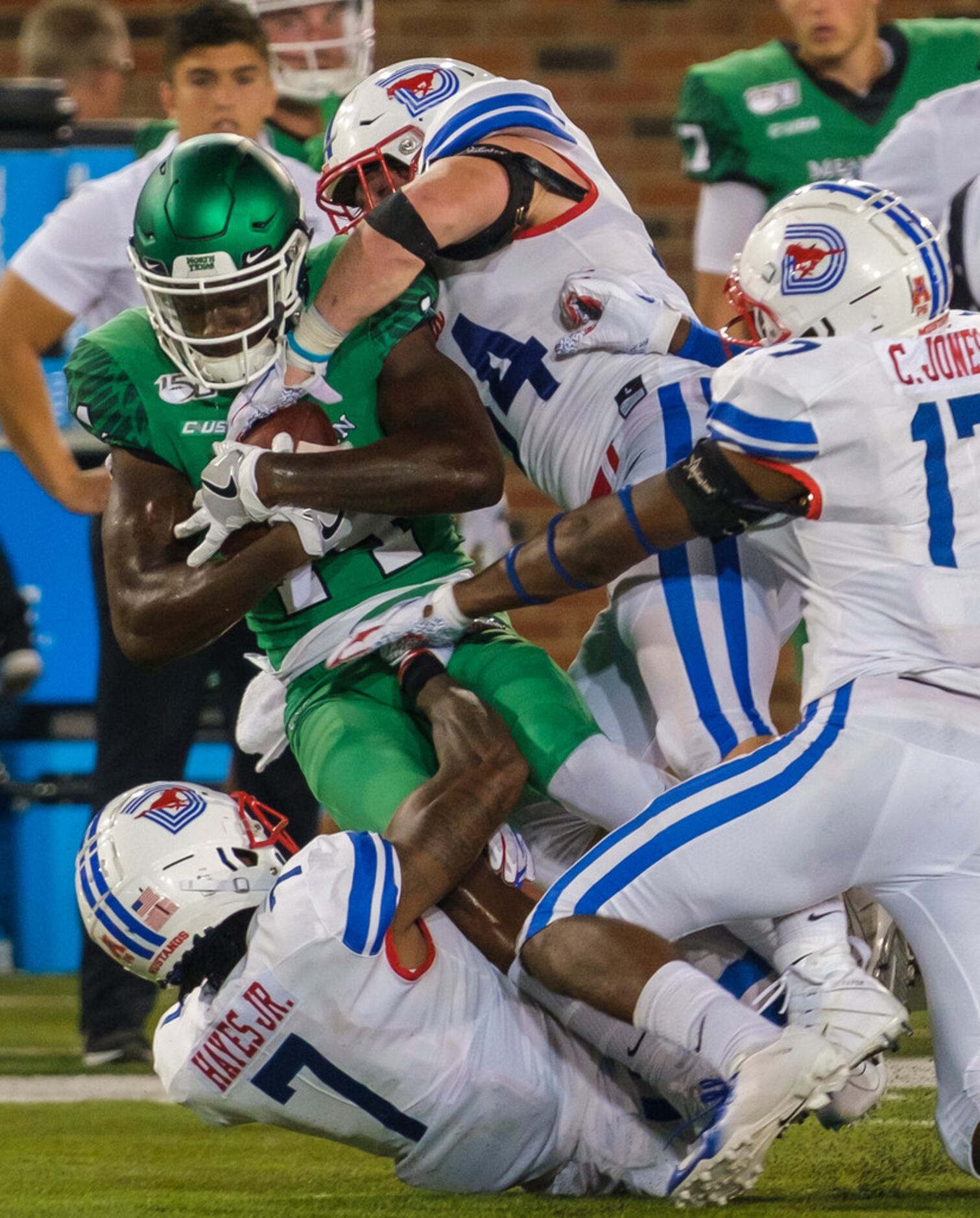 UNT wide receiver Greg White (14) is brought down by SMU cornerback Robert Hayes Jr. (7), ...
