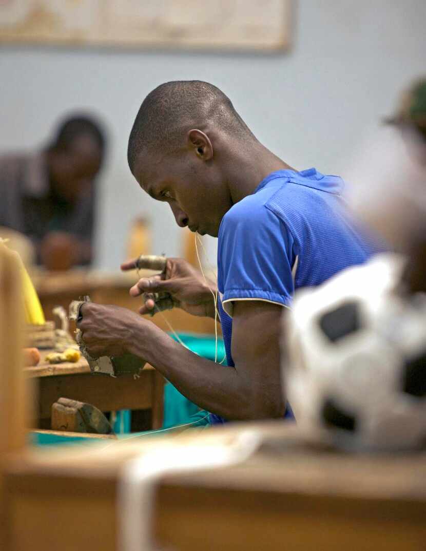 
An employee of Alive & Kicking makes a soccer ball from some of the leather “upcycled” from...