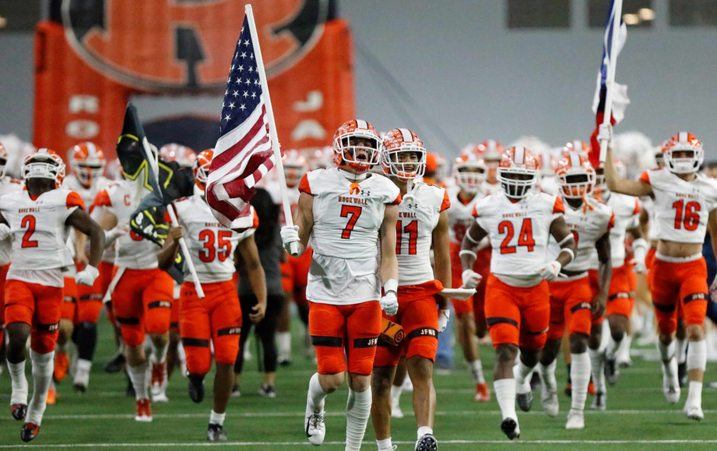 The Rockwall High School football team takes the field before kickoff as Prosper High School...