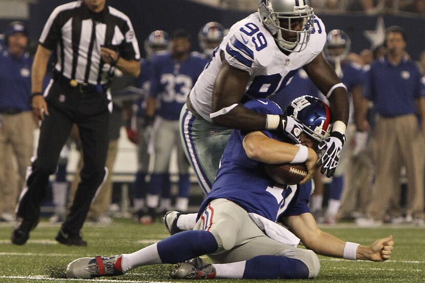New York Giants quarterback Eli Manning (10) is sacked by Dallas Cowboys defensive end...