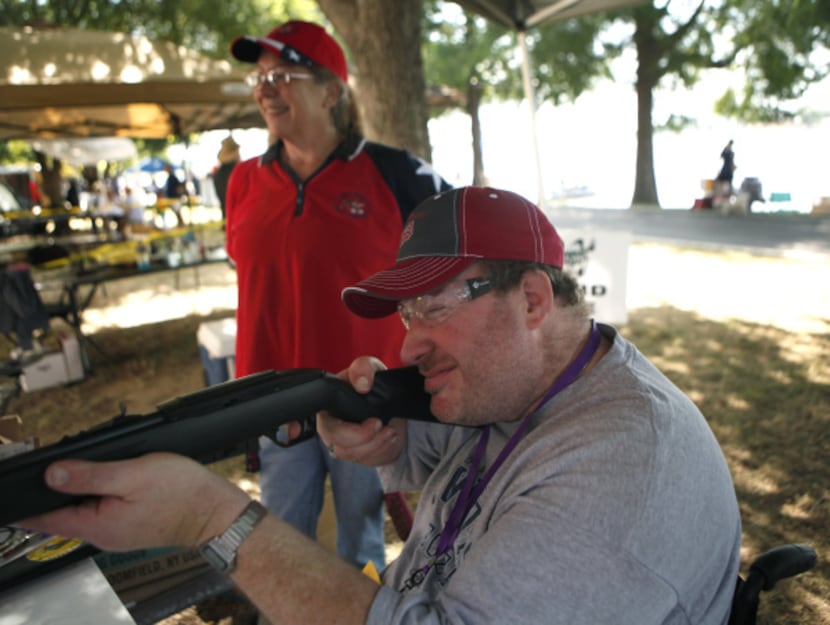 Tim Stone of Dallas took aim with an air rifle as Turning Point volunteer Rhonda Esakov...