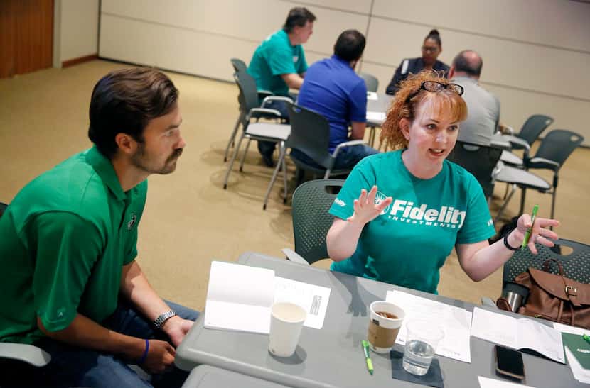 Dallas ISD Skyline economics teacher Peyton Johnson (left) listens to the advice of Fidelity...