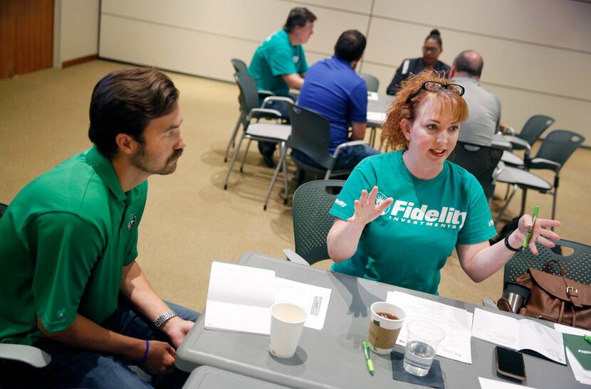 Dallas ISD Skyline economics teacher Peyton Johnson (left) listens to the advice of Fidelity...