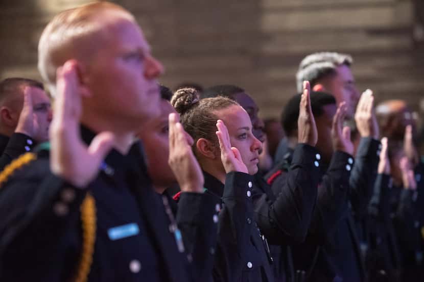 Police Officer Chelsea Boykin, center, raises her right hand with other officers for the...