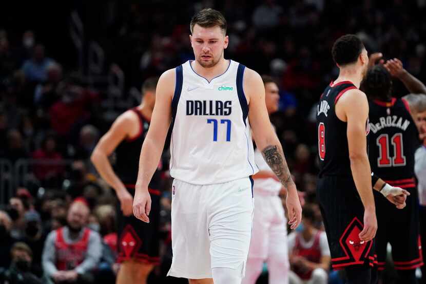 Dallas Mavericks guard Luka Doncic looks down as he walks on the court during the first half...