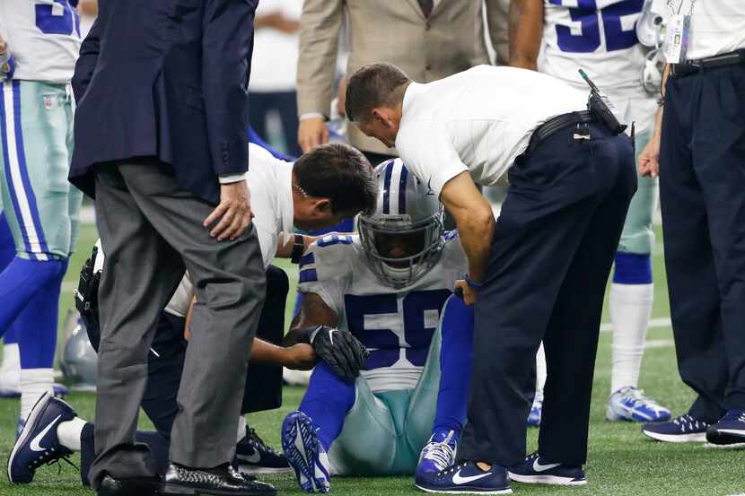 Dallas Cowboys linebacker Anthony Hitchens (59) is assisted by team medical staff after...
