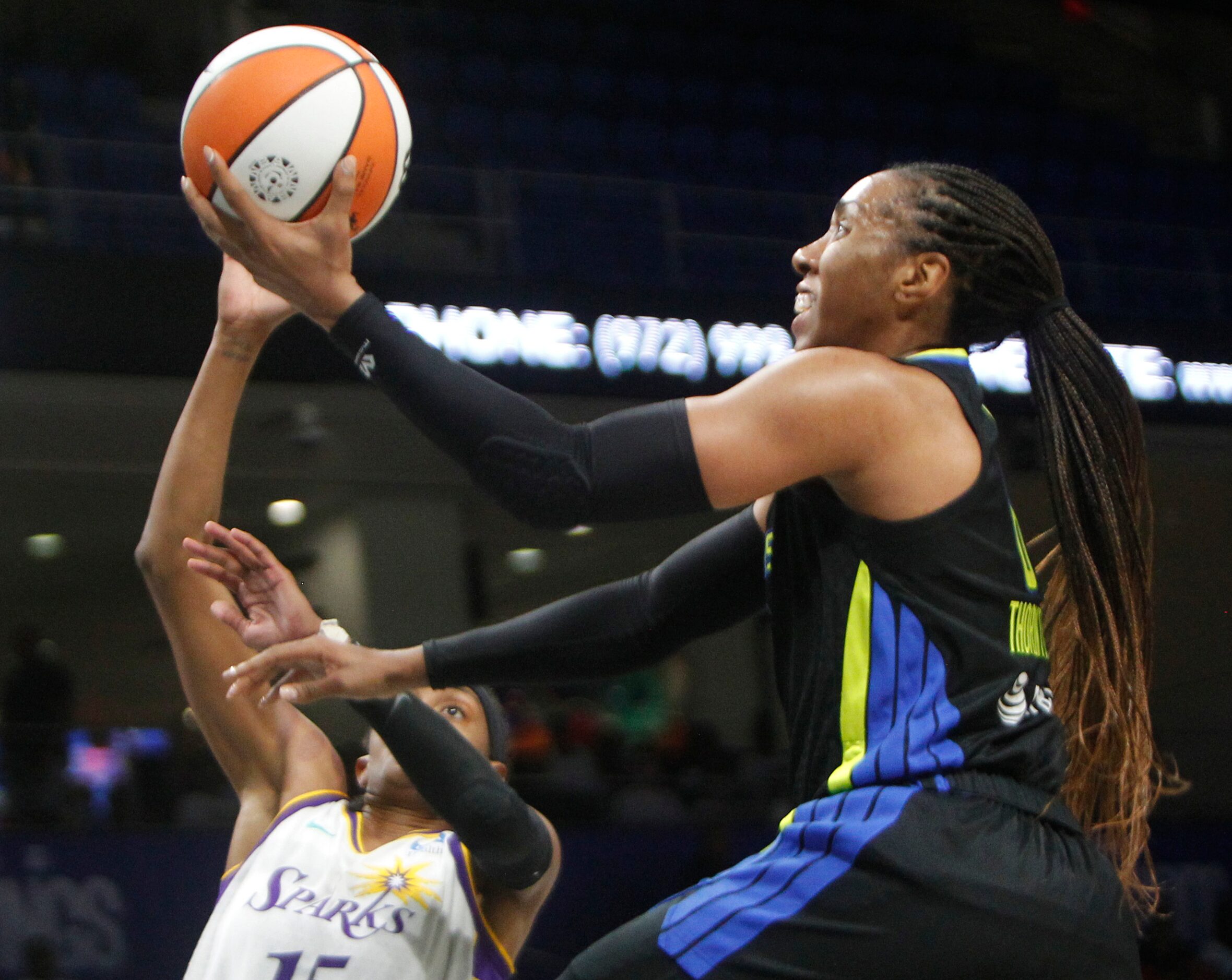 Dallas Wings forward Kayla Thornton (6) drives to the basket as she is defended by LA Sparks...