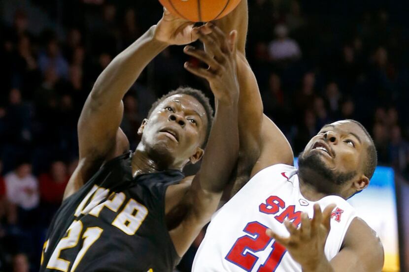SMU guard Ben Emelogu II (right) fights for a rebound with Arkansas-Pine Bluff forward...