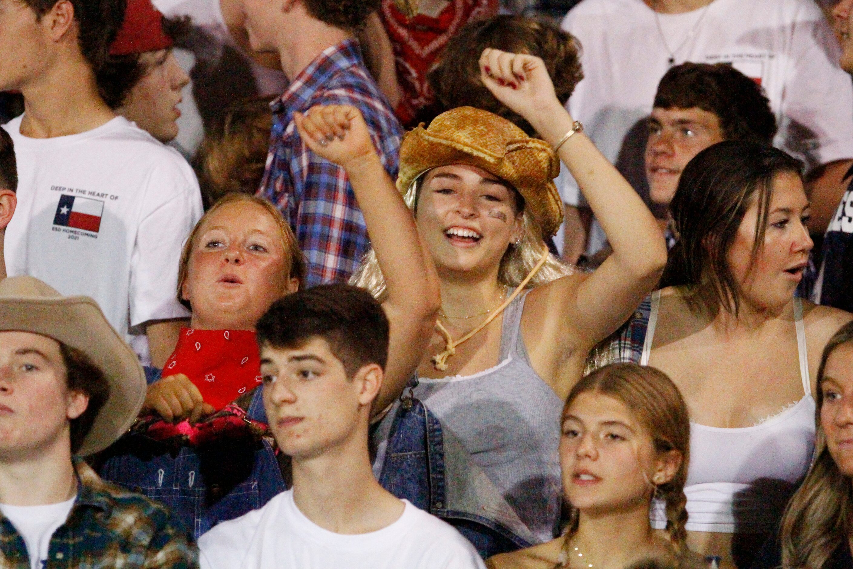 Students from Episcopal School of Dallas, dressed in western attire, dance and celebrate...