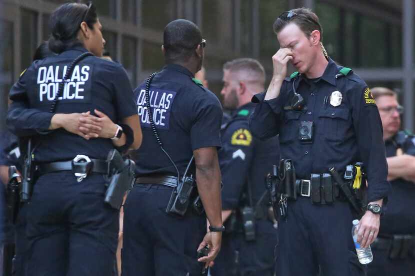 Dallas officers wait outside the emergency room entrance at Texas Health Presbyterian Dallas...