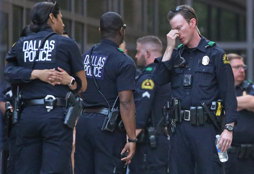 Dallas officers wait outside the emergency room entrance at Texas Health Presbyterian Dallas...