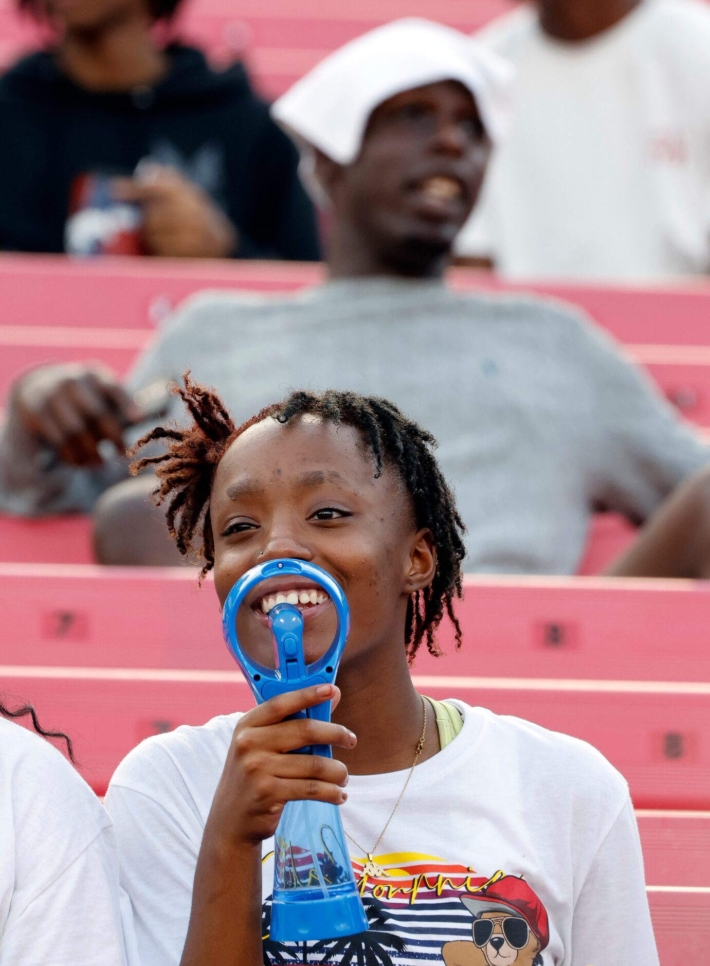 Duncanville freshman Shaniya Stewart keeps cool with a mister fan as she watches the players...