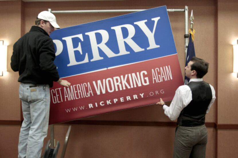 Campaign workers Ryan Vise, left, and Lucas Baiano remove a sign following a news conference...