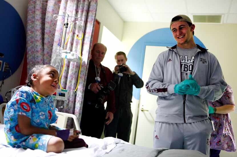 Heisman Trophy winner Johnny Manziel vistits Jairus Wilkes, 7, and other patients along with...