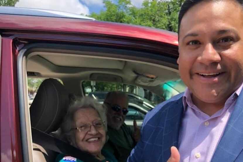 Jason Villalba helped his grandmother get to a drive-through voting station to vote.