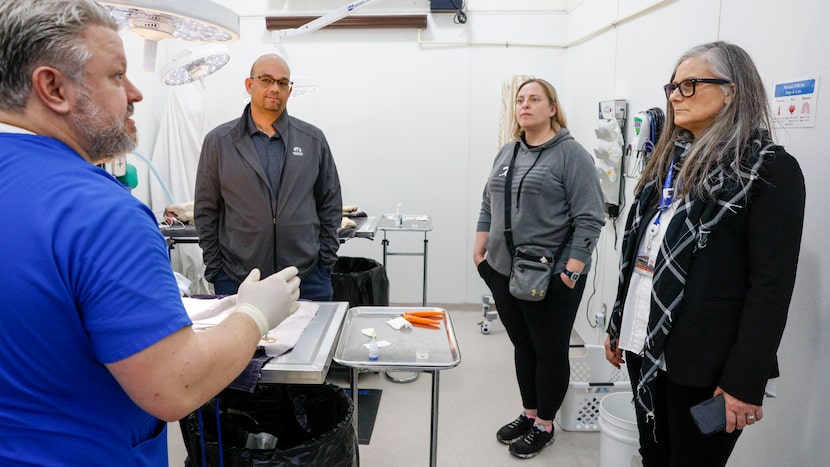 From left, Dallas Animal Services vet Lear Horne talks with Operation Kindness CEO Ed...