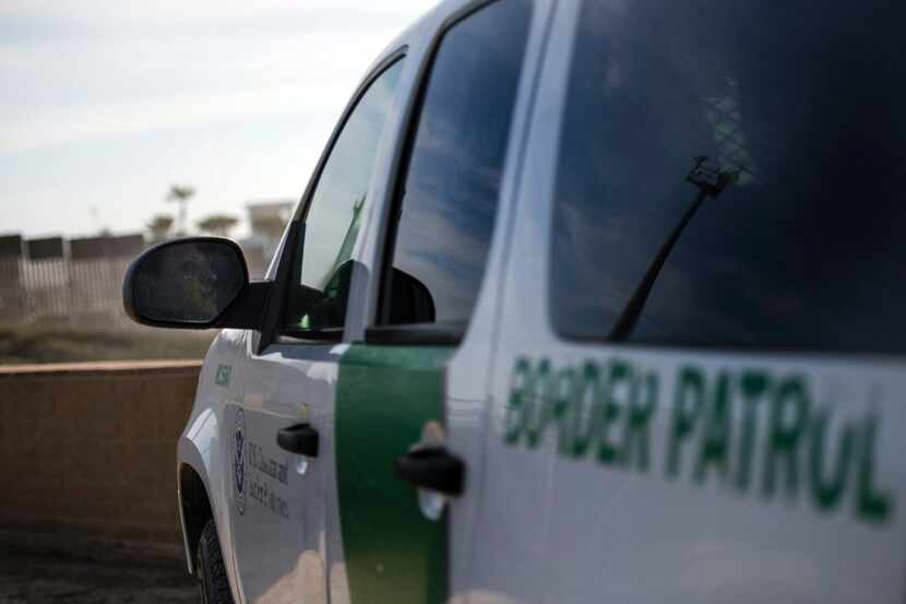 An U.S. Border Patrol officer sits in his vehicle watching the fence line at Border Field...