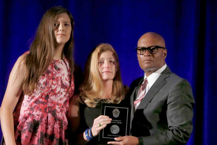 Former Dallas Police Chief David Brown gives Heidi Smith (center) and her daughter Victoria...