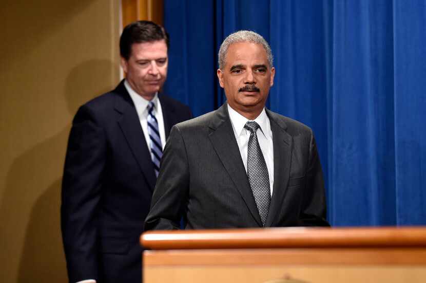 Former Attorney General Eric Holder, right,and FBI Director James Comey arrive for a news...
