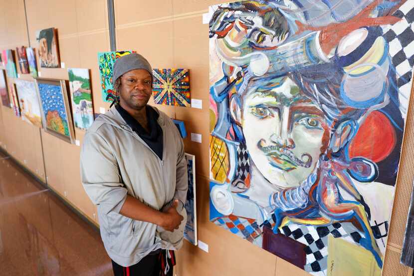 Charles William poses for a photo by his artwork, Unique New York, during an art exhibition...