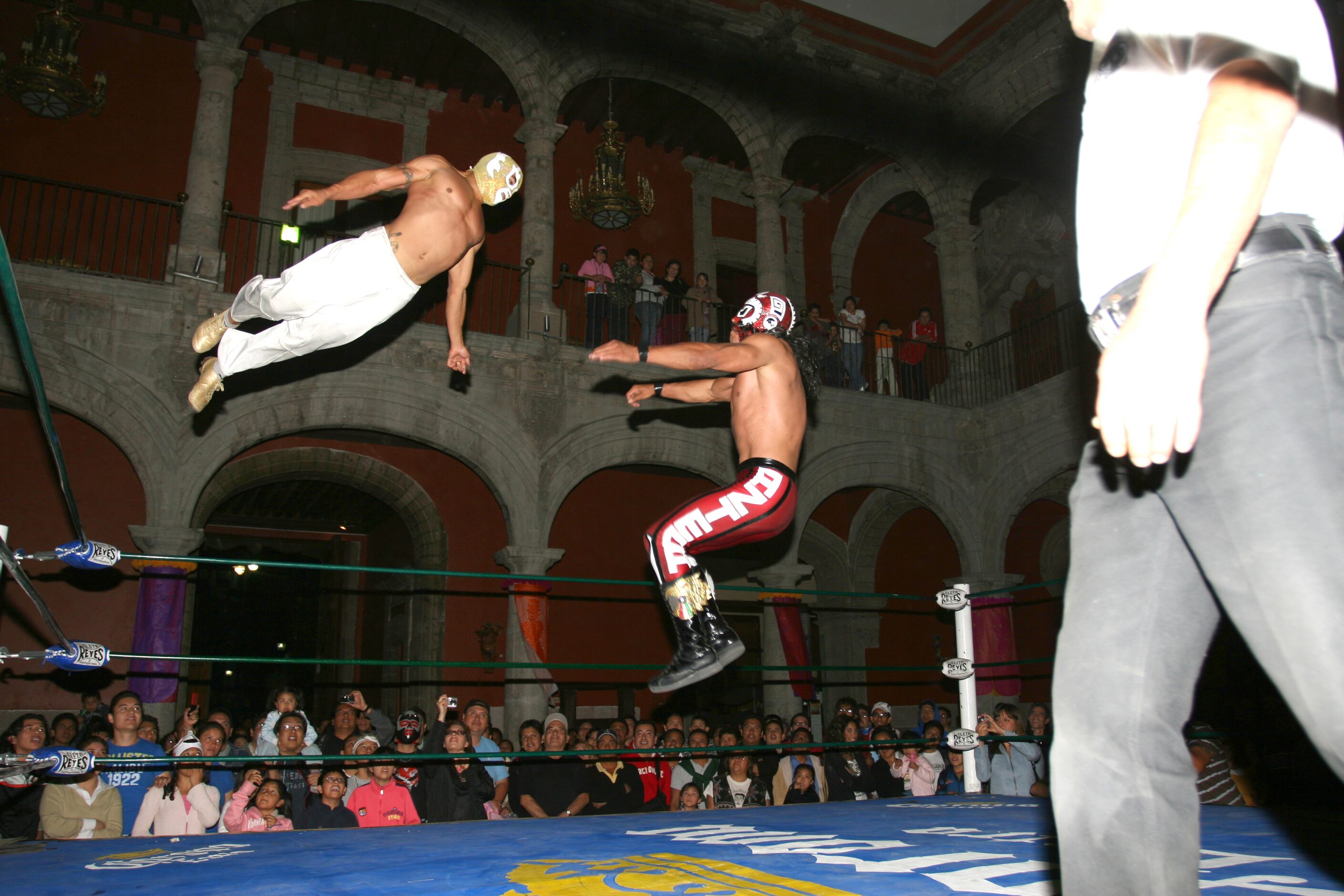 Shaun Leonardo, or El Conquistador de Nueva York (left), leaps from the top turnbuckle...