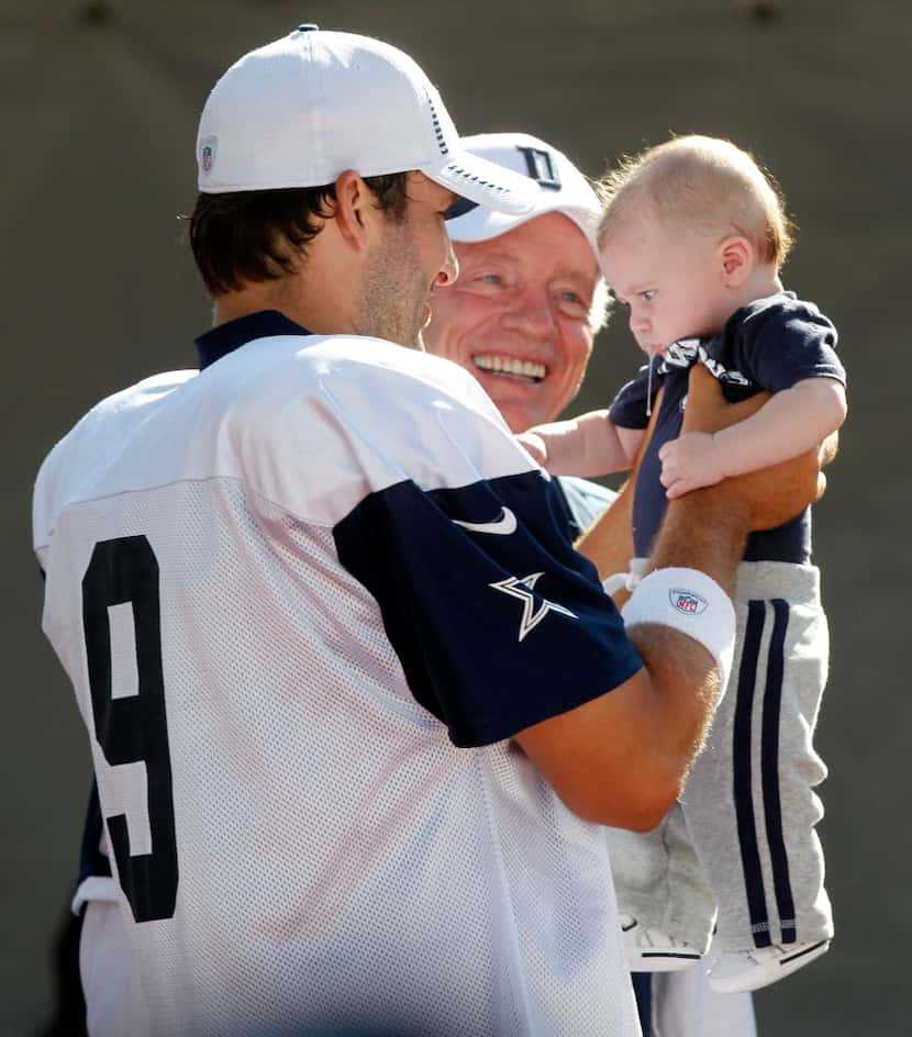 Dallas Cowboys quarterback Tony Romo (9) holds his son, Hawkins, with owner Jerry Jones,...