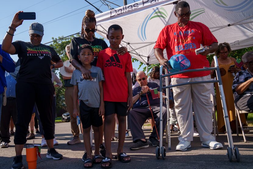 Attendees bow their heads in prayer as the new historical marker is unveiled during a...